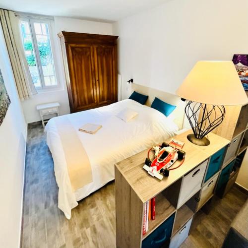 1 dormitorio con 1 cama y 1 mesa con lámpara en L'Olivier, en Cabestany