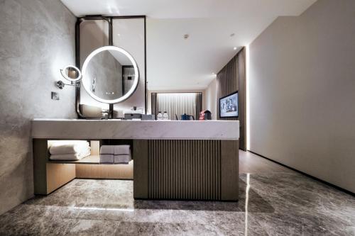 bagno con lavandino e specchio di UrCove by HYATT Shenzhen Luohu a Shenzhen