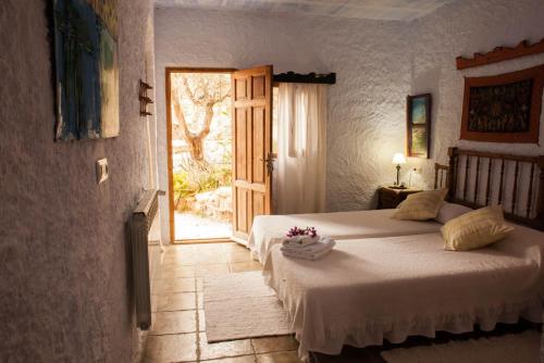 a bedroom with a bed and a door with a window at Casa Rural Aloe Vera in Huércal-Overa