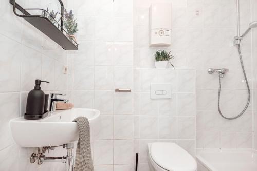 a white bathroom with a sink and a shower at Dream for 4 - Smart TV in Krefeld