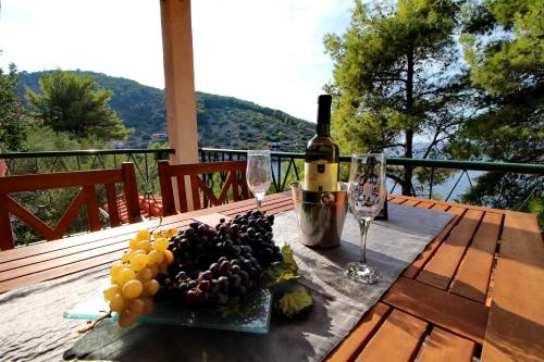 a bottle of wine and a plate of grapes on a table at Apartments Sunset in Blato