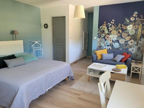 une chambre avec un lit, un canapé et une table dans l'établissement L'Atelier 7, à Saintes