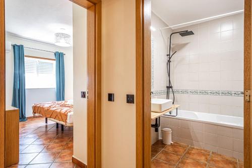 uma casa de banho com uma banheira, um lavatório e uma cama em BeGuest Jardins Vale Parra Apartment em Albufeira