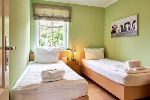 duas camas num quarto com paredes verdes em Hardina Whg 3, Stockmannsweg em Wyk auf Föhr