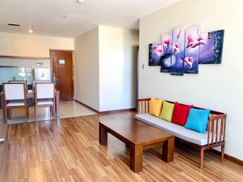 a living room with a couch with colorful pillows on it at Avatar Danang Hotel in Da Nang