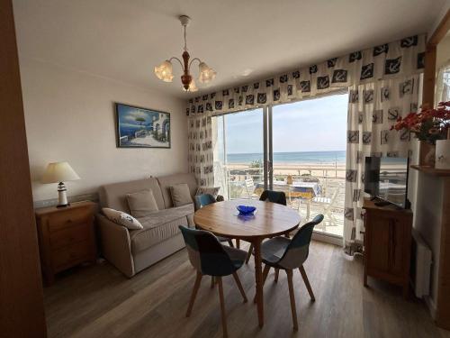 un salon avec une table, des chaises et un canapé dans l'établissement Studio Cabine 4 Couchages avec Balcon et Parking - Saint-Jean-de-Monts - FR-1-224C-18, à Saint-Jean-de-Monts