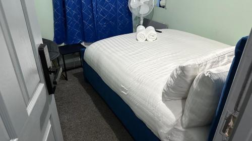 a bedroom with a blue bed with two shoes on it at Homestay in Walsall in Walsall