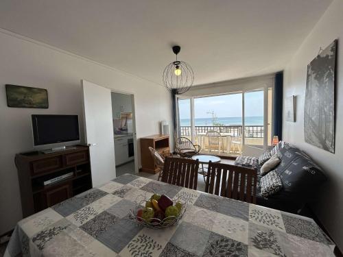 - un salon avec une table à manger offrant une vue sur l'océan dans l'établissement Appart 3 pièces face mer, 6 couchages, proche plage et commerces, Saint-Jean-de-Monts - FR-1-224C-225, à Saint-Jean-de-Monts