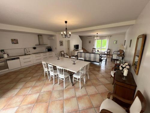 una cucina e un soggiorno con tavolo e sedie di Les Terrasses Binel à Ronsac ad Aigrefeuille