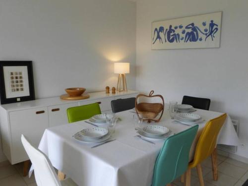 - une table à manger avec une nappe et des chaises blanches dans l'établissement Maison avec piscine chauffée, 4 pièces, 6 couchages près de Saint-Gilles-Croix-de-Vie - FR-1-224-671, à Saint-Révérend