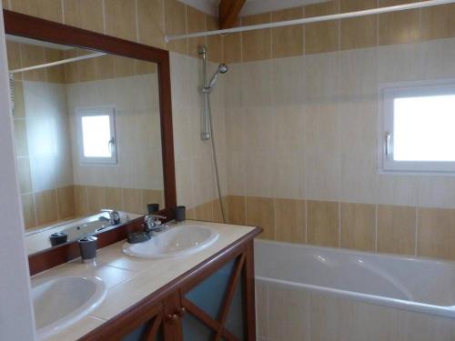 une salle de bain avec deux lavabos, une baignoire et un miroir dans l'établissement Maison avec piscine chauffée, 4 pièces, 6 couchages près de Saint-Gilles-Croix-de-Vie - FR-1-224-671, à Saint-Révérend