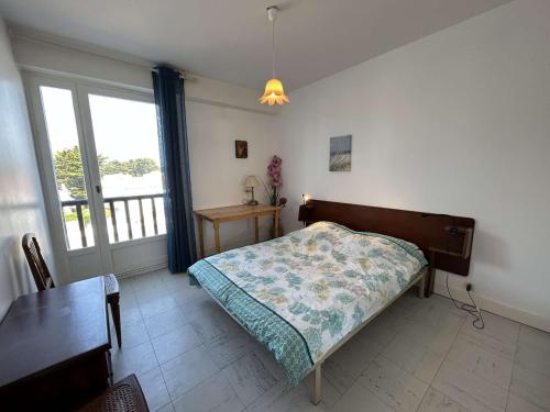 une chambre avec un lit, une table et une fenêtre dans l'établissement Appart 3 pièces face mer, 6 couchages, proche plage et commerces, Saint-Jean-de-Monts - FR-1-224C-225, à Saint-Jean-de-Monts