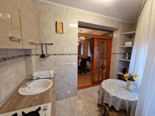 een badkamer met een wastafel en een tafel in een kamer bij Vila 33 in Constanţa