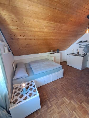 a bed in a room with a wooden ceiling at Schwarzwaldstüble 