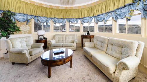 a living room with couches and chairs and a table at The Atholl Palace in Pitlochry