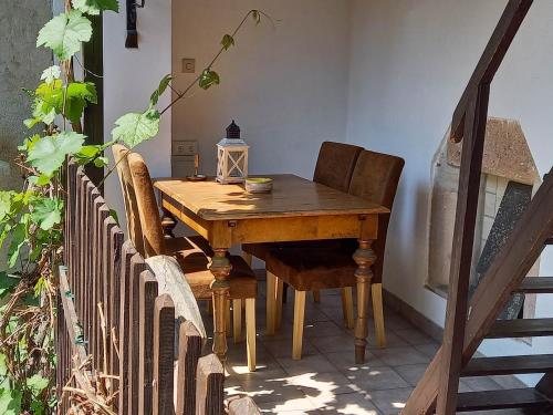 una mesa de madera con 2 sillas y una lámpara. en Gästehaus auf der Kunstmeile en Krems an der Donau