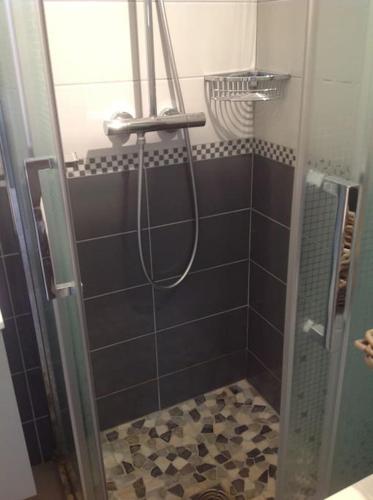 une salle de bain avec une douche avec une porte vitrée dans l'établissement EOLE, Idéalement situé sur le port de St Martin de Re, à Saint-Martin-de-Ré