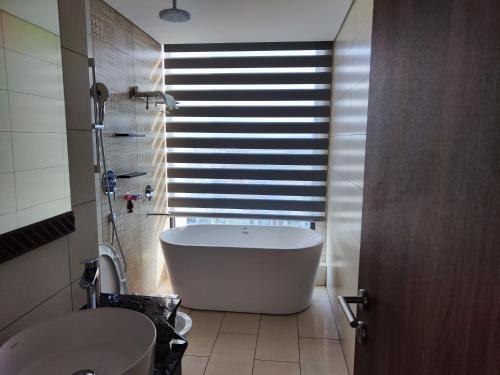 uma casa de banho com uma banheira, um lavatório e uma janela em Hoa vàng trên cỏ xanh em Phu Yen