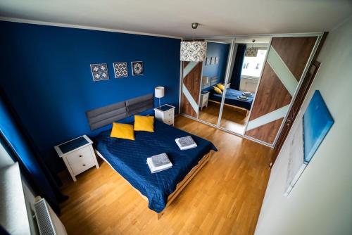 1 dormitorio con cama con almohadas amarillas y espejo en Citilife Apartament dla 4 osób, en Gdansk