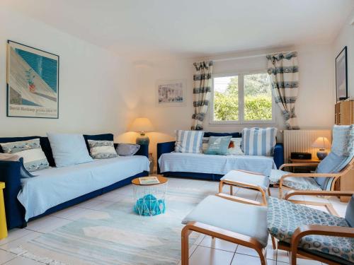 un salon avec un canapé bleu et des chaises dans l'établissement Maison spacieuse à Carnac, proche plage, 3 terrasses, jardin clos, Wifi, pour 7 pers, 2* - FR-1-477-220, à Carnac