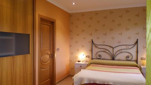 a bedroom with a bed and a flat screen tv at Casa Aida in Foz