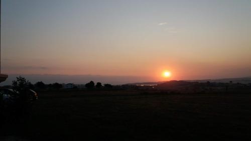 a sunset over a field with the sun in the sky at Casa Aida in Foz