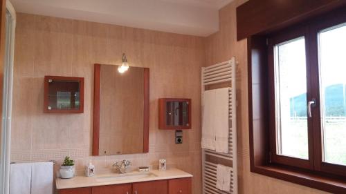 a bathroom with a sink and a mirror at Casa Aida in Foz