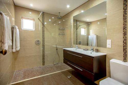 a bathroom with a shower and a sink and a mirror at Balaia Golf Village in Albufeira