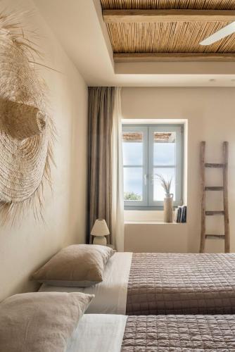 a bedroom with a bed and a window and a ladder at Verina Astra in Artemonas