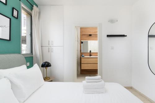 a bedroom with a white bed and a bathroom at Downtown apartment 3BDR with city view in Giv‘at Rambam