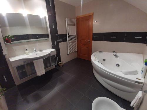 a bathroom with a tub and a sink at Casa Aida in Foz