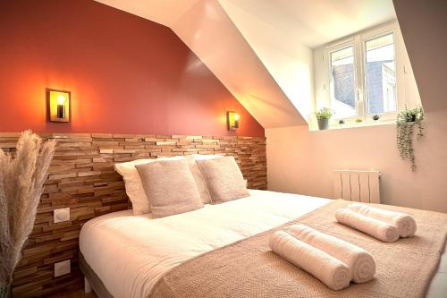 une chambre avec un grand lit avec deux oreillers dessus dans l'établissement L'Adresse-Standing proche plage avec parking, au Havre