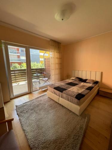 a bedroom with a bed and a large window at Cozy Apartment, Jaukus Butas Centre, internet in Klaipėda