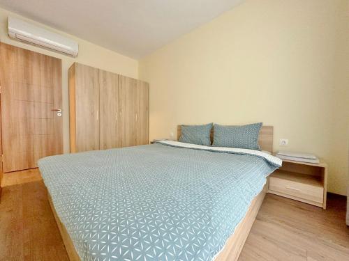 um quarto com uma cama grande e um edredão azul em Central Flat & Free Parking em Varna City