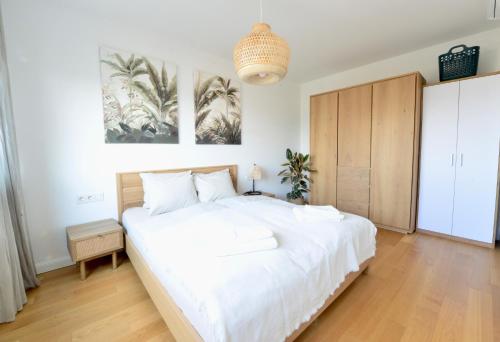 1 dormitorio con 1 cama blanca grande y suelo de madera en Modern & Stylish Close to Centre, en Viena