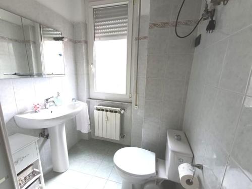 Casa SOFIA La Spezia في لا سبيتسيا: حمام أبيض مع حوض ومرحاض