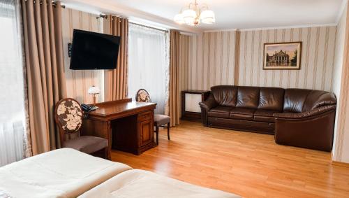 Habitación de hotel con sofá y escritorio en Hotel Lviv, en Leópolis