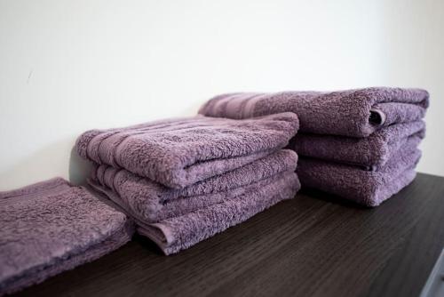 a pile of purple towels sitting on a table at Maison individuelle avec piscine privative. in Saint-Médard-en-Jalles