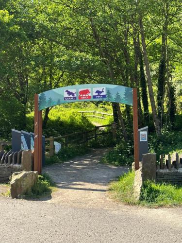 an archway with signs on it in a park at Ty Pentref - Cwmcarn Village House in Cwmcarn