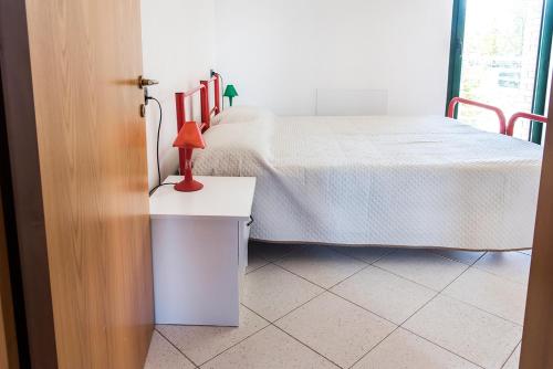 um quarto com uma cama com um candeeiro vermelho sobre uma mesa em SE002 - Senigallia, bilocale fronte mare con spiaggia em Senigallia