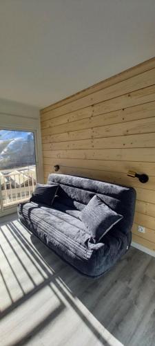 - une chambre avec un lit et un mur en bois dans l'établissement Appartements et studios dans un gite au pied des pistes, à La Mongie