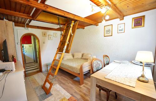 a room with a bed and a desk and a ladder at Emerald Bell Cottage - Smaragdni Zvonček 