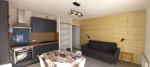 - une cuisine avec un canapé et une table dans une chambre dans l'établissement Appartements et studios dans un gite au pied des pistes, à La Mongie