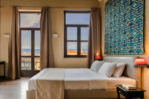 a bedroom with a large bed and two windows at Alcanea Boutique Hotel in Chania Town