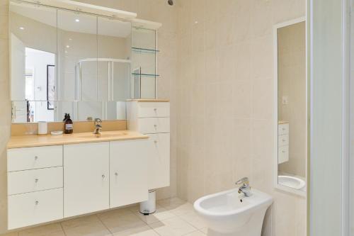 a white bathroom with a sink and a toilet at Magnolia - Charmante maison avec jardin in Nantes