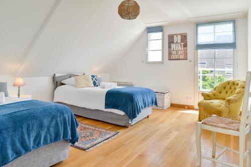 a bedroom with two beds and a chair at Magnolia - Charmante maison avec jardin in Nantes