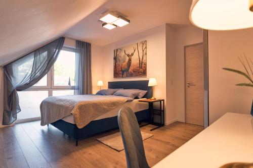 a bedroom with a bed and a large window at 118qm Premium Apartment - Birkenfeld National Park in Ellweiler