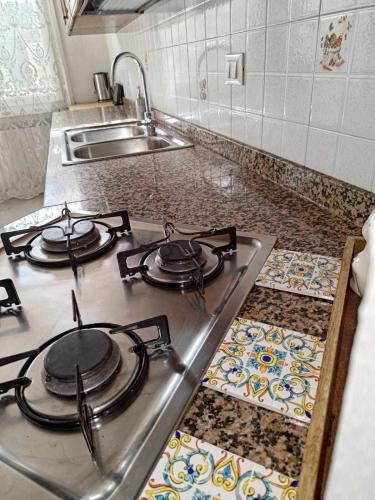 a kitchen stove with four burners and a sink at Traghetto vecchio house in Cavallino-Treporti