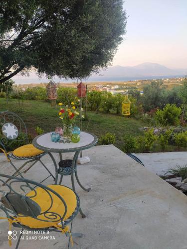a table and chairs with a vase of flowers on it at Villa View in Oropós