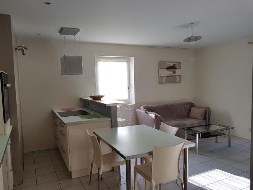 eine Küche und ein Wohnzimmer mit einem Tisch und einem Sofa in der Unterkunft F2 meublé à Crest in Crest
